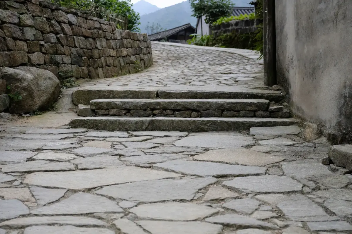 A stone lane in a Moganshan village, with the paving change and a short flight of steps where the slope steepens