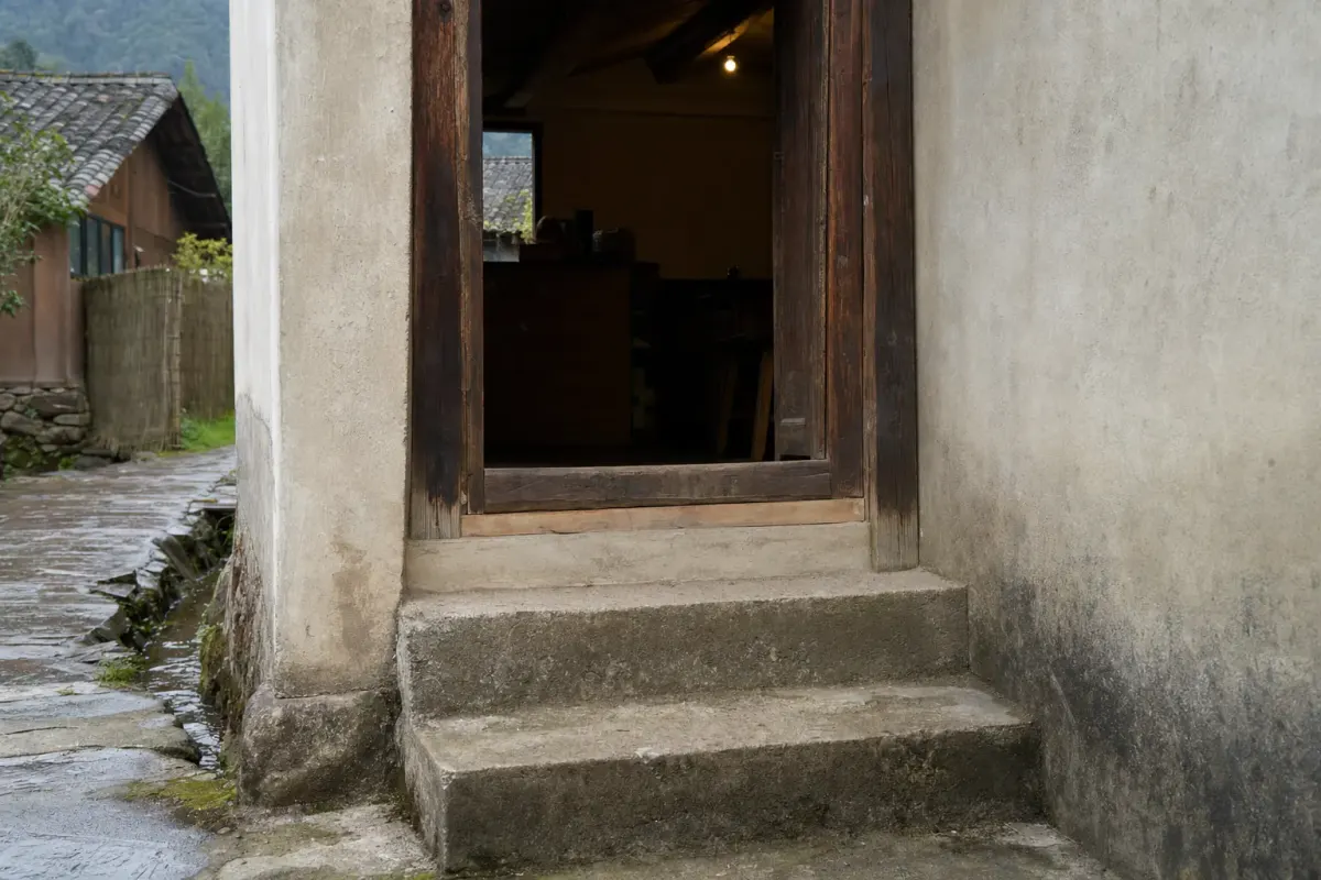 The entrance of a converted village guesthouse at Moganshan, with two stone steps up from the lane to the door