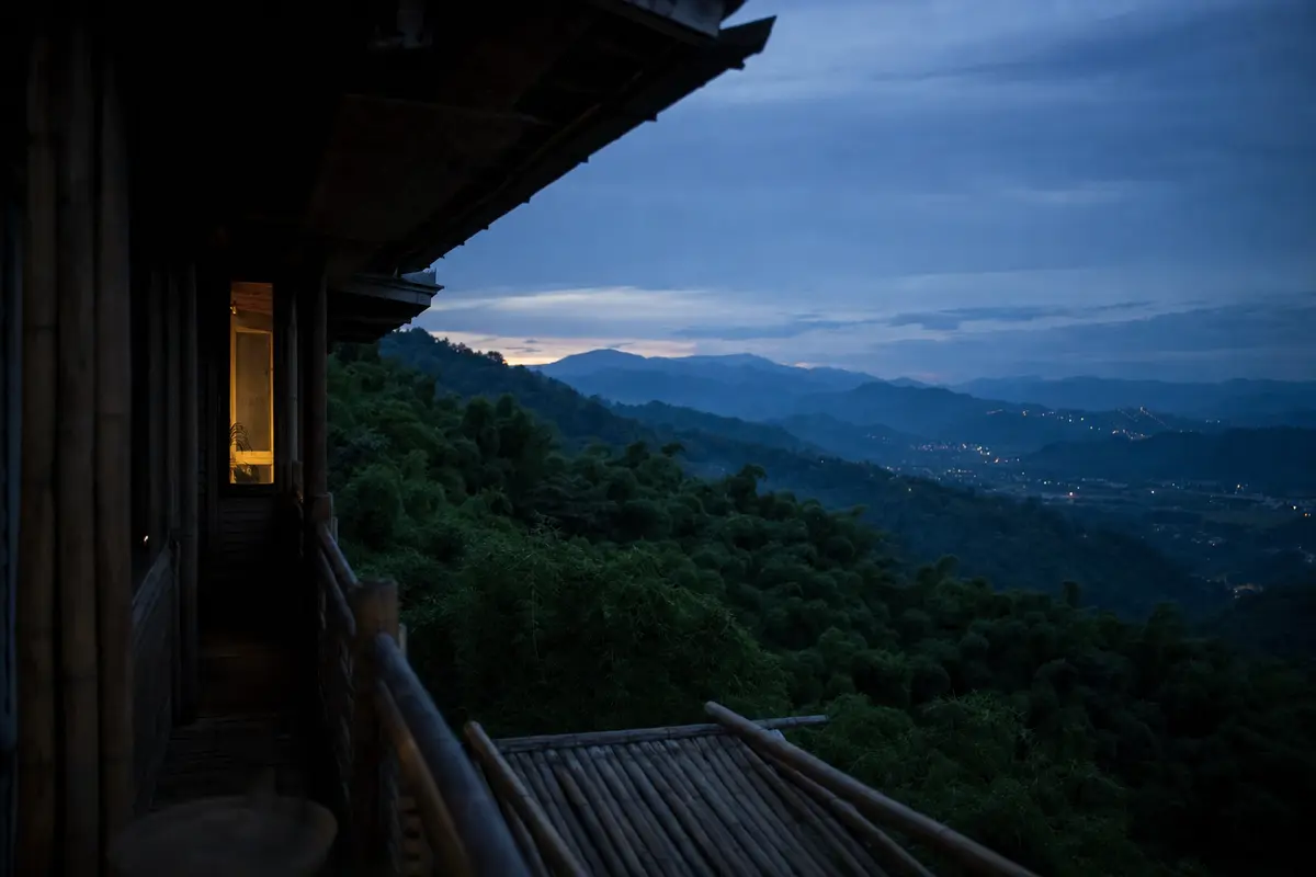 Dusk over a bamboo ridge seen from a villa terrace with valley lights below