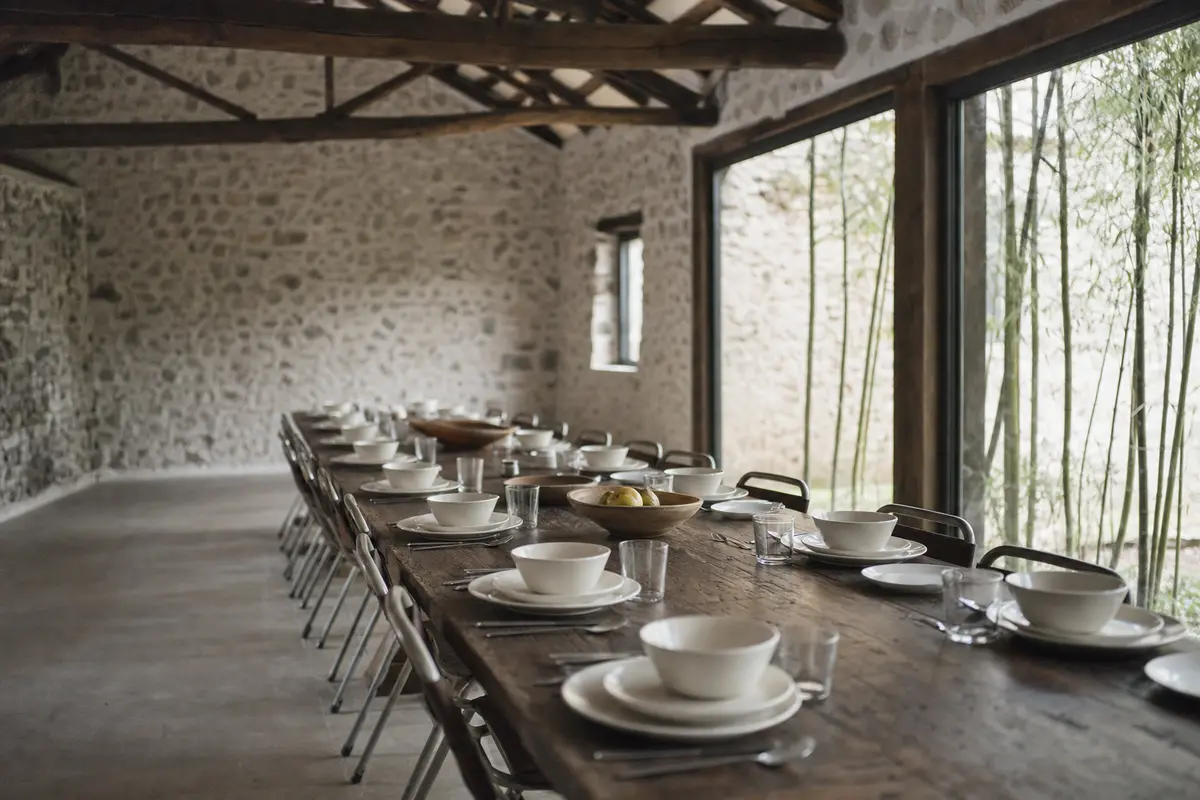 A long communal table set for twelve inside a converted stone villa