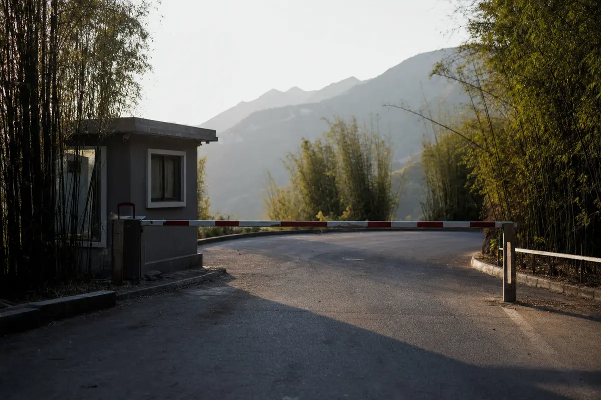 A road barrier and control hut at a scenic area entrance in late afternoon