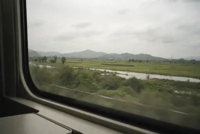 The flat green delta countryside of eastern China seen from a moving train window
