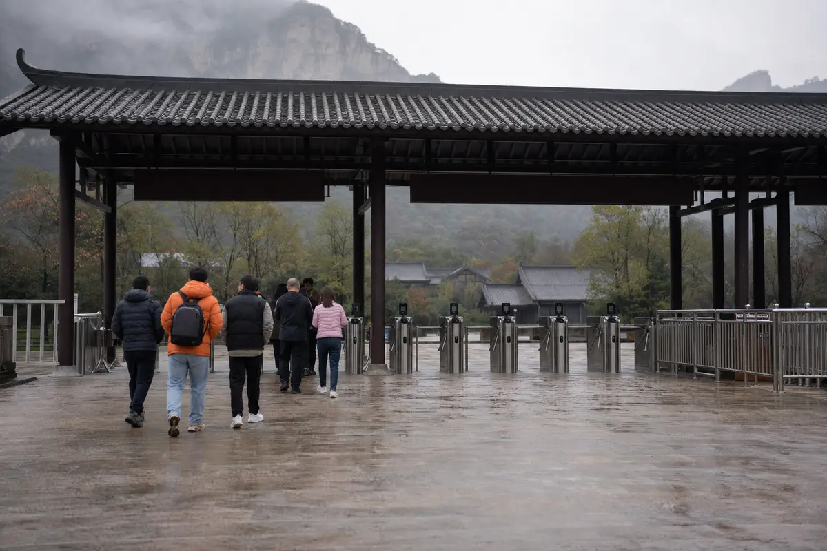 A line of turnstiles under a canopy at the entrance to a scenic area