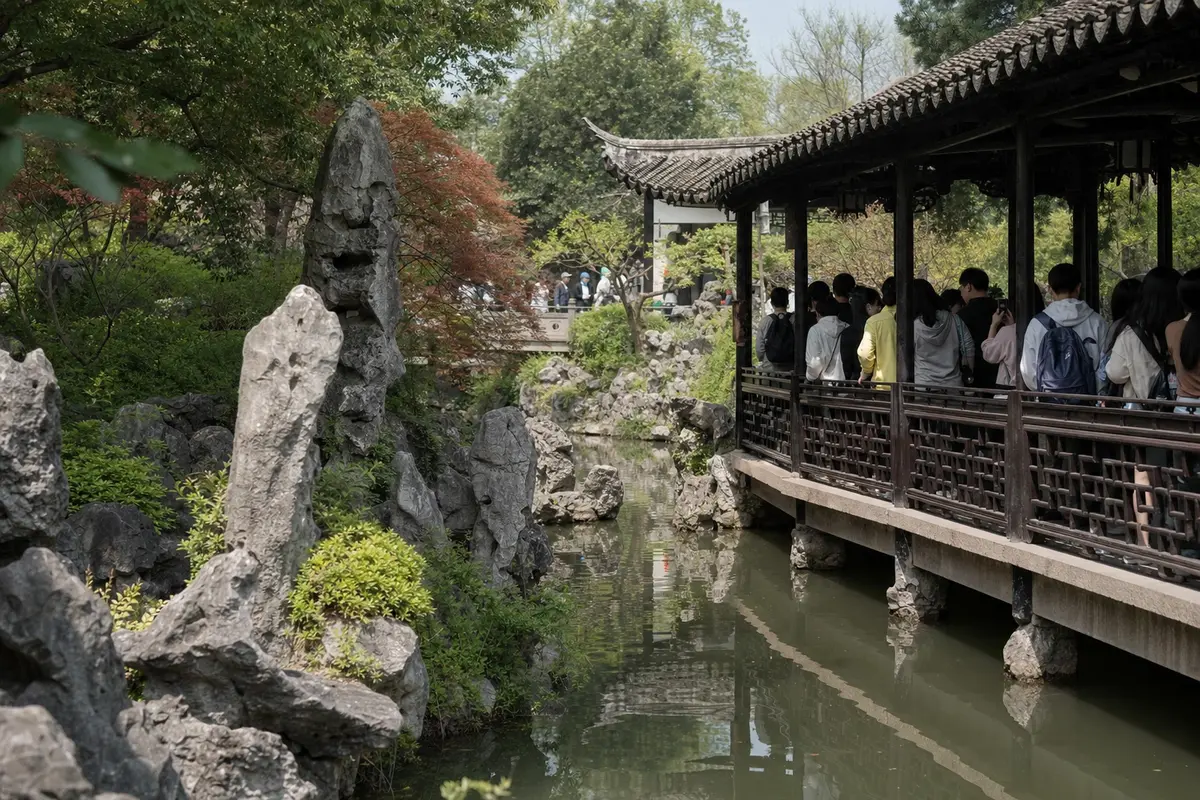 Visitors on a covered walkway in a busy classical Chinese garden