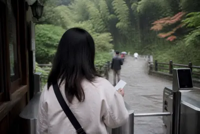 A visitor holding a ticket at the entry barrier of the Moganshan scenic area