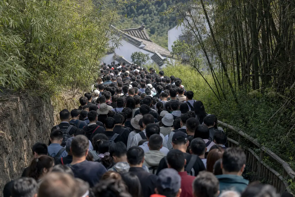 Visitors pressed together in a bottleneck at a mountain attraction entrance
