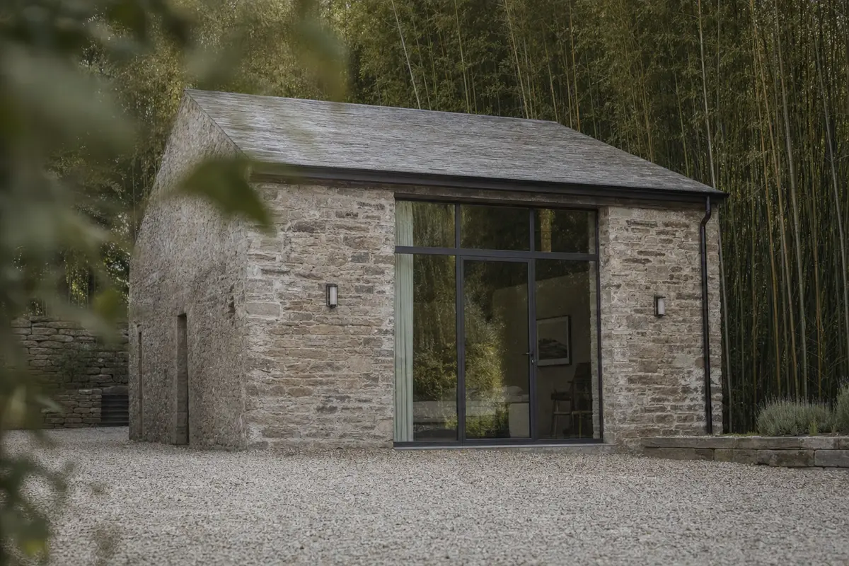 A converted stone barn guesthouse with new full height glazing set into old walls