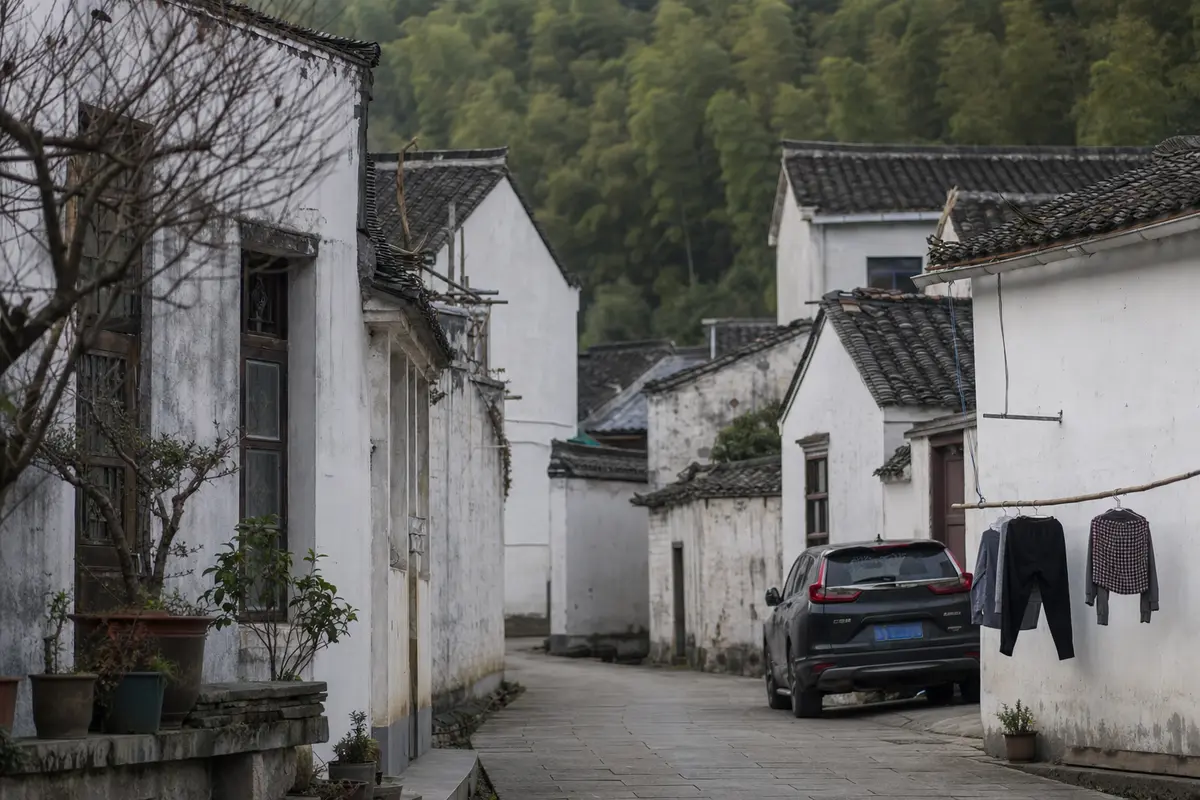 A quiet village lane on a weekday morning with one parked car and laundry drying